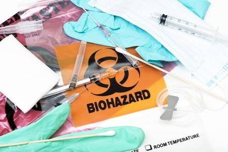Biohazard medical waste bags with used syringes, needles, bandages, and other medical waste.